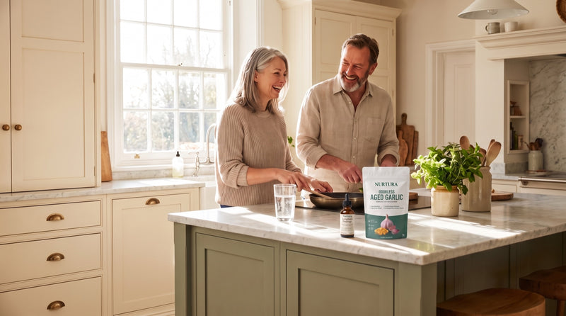 A couple in their fifties laughing in a bright kitchen with their Nurtura supplements on the counter