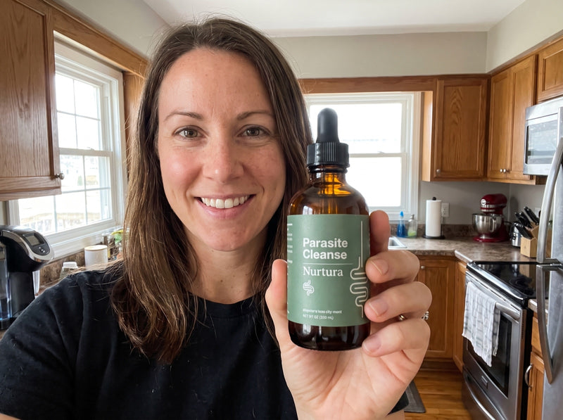 Nurtura customer holding her Parasite Cleanse bottle